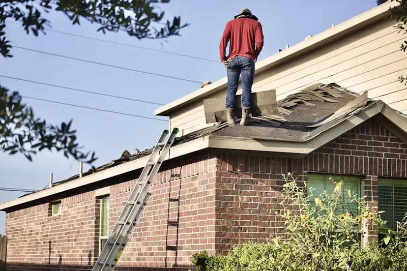 Professional roofer working on a residential roof in Overbrook
